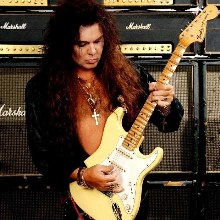 Yngwie Malmsteen playing his Fender Stratocaster in front of Marshall stacks