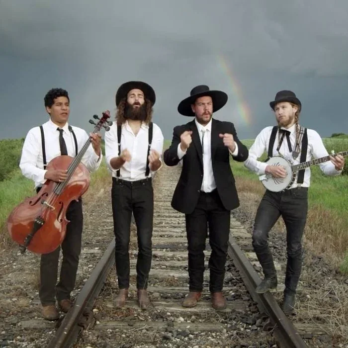 The Dead South on railroad tracks with cello and banjo